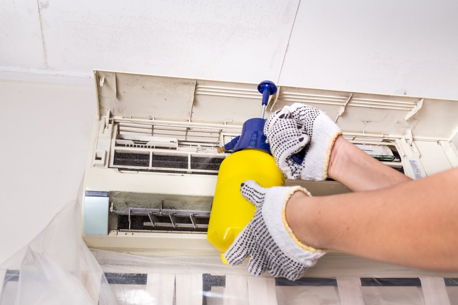 technician-spraying-chemical-water-onto-air-condit-PPEB8PH.jpg